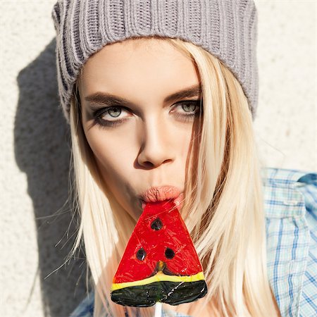 simsearch:400-07509968,k - Portrait of sexy blond girl with smokey eye makeup who sucks watermelon lollipop with her plump passionate lips Stock Photo - Budget Royalty-Free & Subscription, Code: 400-07477509
