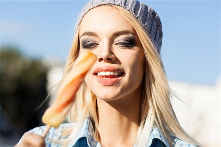 simsearch:400-07509968,k - Smiling blond girl with plump sexy lips and smokey eye make up looks at sweet delicious fruit ice cream Stock Photo - Budget Royalty-Free & Subscription, Code: 400-07477503