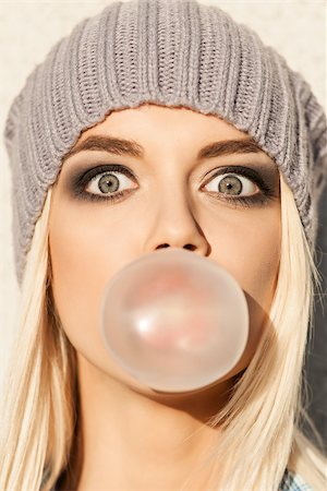 simsearch:400-07509968,k - Portrait of beautiful young blond girl in beanie hat blows big bubble from bubble gum Stock Photo - Budget Royalty-Free & Subscription, Code: 400-07477514