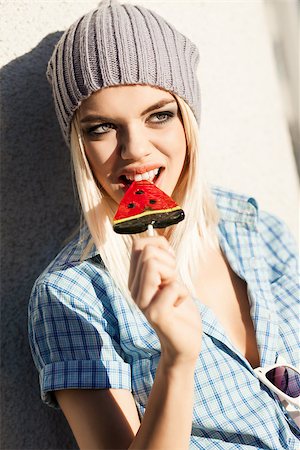 simsearch:400-07509968,k - Portrait of beautiful smiling blond girl who bites sweet bright watermelon lollipop with healthy white teeth Stock Photo - Budget Royalty-Free & Subscription, Code: 400-07477513
