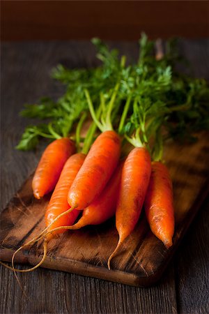 simsearch:400-07982459,k - Bunch of fresh carrots  on an old wooden cooking board. Photographie de stock - Aubaine LD & Abonnement, Code: 400-07477651