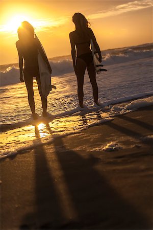 surfboard beach sunset friends - Beautiful young women surfer girls in bikinis with surfboards on a beach at sunset or sunrise Stock Photo - Budget Royalty-Free & Subscription, Code: 400-07479135