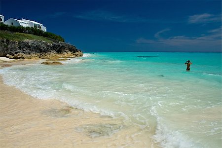A tropical coastline with a lone girl in the ocean Stockbilder - Microstock & Abonnement, Bildnummer: 400-07479144