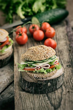 simsearch:400-06067567,k - Delicious ham, cheese and salami sandwich with vegetables, lettuce, cherry tomatoes in natural setting with wooden background Stockbilder - Microstock & Abonnement, Bildnummer: 400-07479420