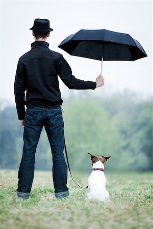 people animal cuddle - friendship between dog and owner standing in the rain with umbrella Stock Photo - Budget Royalty-Free & Subscription, Code: 400-07479578