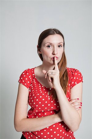 pursed - Studio portrait of attractive woman with finger over pursed lips to signal for quiet Stock Photo - Budget Royalty-Free & Subscription, Code: 400-07470197