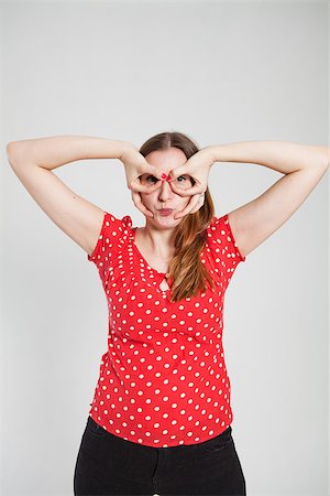 pursed - Studio portrait of attractive woman with pursed lips looking through finger goggles Stock Photo - Budget Royalty-Free & Subscription, Code: 400-07470192