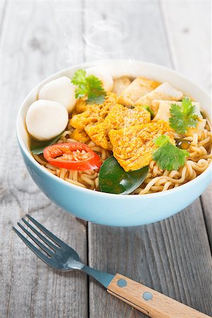 simsearch:400-05297094,k - Spicy curry instant noodles soup with fork on wooden dining table. Fresh cooked, hot with steamed smoke. Fotografie stock - Microstock e Abbonamento, Codice: 400-07470844