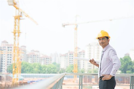 engineer background - Portrait of a smiling Asian Indian male contractor engineer with hard hat standing at construction site. Stock Photo - Budget Royalty-Free & Subscription, Code: 400-07470860