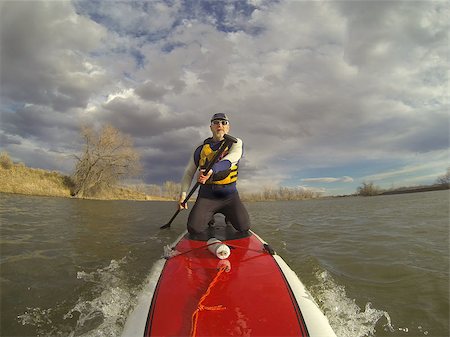 simsearch:400-07795226,k - mature male paddler in wetsuit and life jacket enjoying workout on a stand up paddleboard (SUP), windy lake in one of nature areas in Fort Collins, Colorado,  distorted wide angle view Foto de stock - Royalty-Free Super Valor e Assinatura, Número: 400-07470975