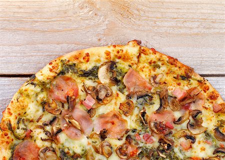 simsearch:400-07625359,k - Part of Freshly Baked Pizza with Edible Mushrooms, Bacon, Cheese and Spinach Sauce closeup on Wooden background. Top View Photographie de stock - Aubaine LD & Abonnement, Code: 400-07473097