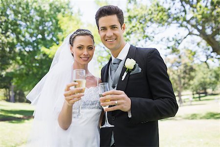 Portrait of newlywed couple toasting champagne in park Stock Photo - Budget Royalty-Free & Subscription, Code: 400-07473207