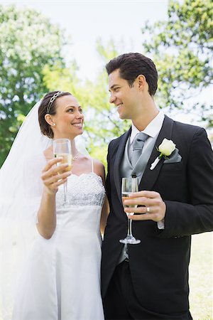 Romantic bride and groom having champagne while looking at each other in park Stock Photo - Budget Royalty-Free & Subscription, Code: 400-07473209
