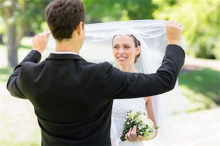 simsearch:400-07473236,k - Young loving groom lifting veil of bride in park Stockbilder - Microstock & Abonnement, Bildnummer: 400-07473217