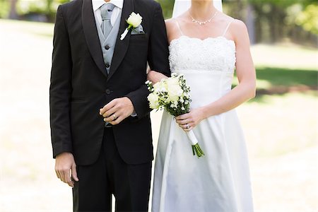 Mid section of newlywed couple holding hands in park Foto de stock - Super Valor sin royalties y Suscripción, Código: 400-07473227