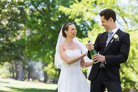 simsearch:400-07473236,k - Young newlywed couple opening champagne bottle in park Stockbilder - Microstock & Abonnement, Bildnummer: 400-07473235