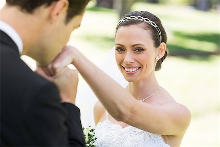 simsearch:400-07473236,k - Young groom kissing on hand of beautiful bride in park Stockbilder - Microstock & Abonnement, Bildnummer: 400-07473231