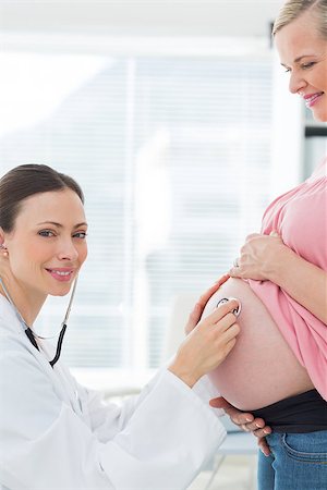 Portrait of beautiful doctor examining pregnant woman with stethoscope in clinic Stock Photo - Budget Royalty-Free & Subscription, Code: 400-07473269