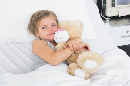 sick patients hugging - High angle portrait of cute girl embracing teddy bear while lying in hospital bed Photographie de stock - Aubaine LD & Abonnement, Code: 400-07473364