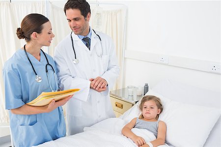 simsearch:400-04307817,k - Doctors discussing while attending cute sick girl in hospital ward Stock Photo - Budget Royalty-Free & Subscription, Code: 400-07473369