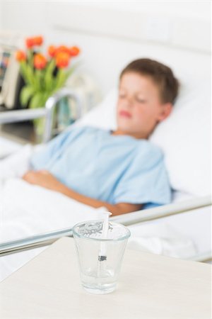 simsearch:400-07473471,k - Focus on syringe in glass with boy resting in hospital ward Photographie de stock - Aubaine LD & Abonnement, Code: 400-07473446