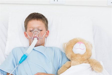 Sick boy wearing oxygen mask sleeping beside stuffed toy in hospital bed Stock Photo - Budget Royalty-Free & Subscription, Code: 400-07473456