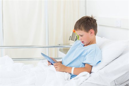 simsearch:400-07473471,k - Side view of little boy using digital tablet in hospital bed Photographie de stock - Aubaine LD & Abonnement, Code: 400-07473475