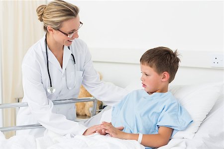 simsearch:400-06734741,k - Happy female doctor examining sick boy in hospital bed Photographie de stock - Aubaine LD & Abonnement, Code: 400-07473478