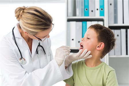 simsearch:400-06734647,k - Female doctor looking into the mouth of boy in clinic Stock Photo - Budget Royalty-Free & Subscription, Code: 400-07473517