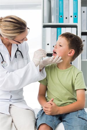 simsearch:400-06734647,k - Female doctor examining mouth of little boy in clinic Stock Photo - Budget Royalty-Free & Subscription, Code: 400-07473518