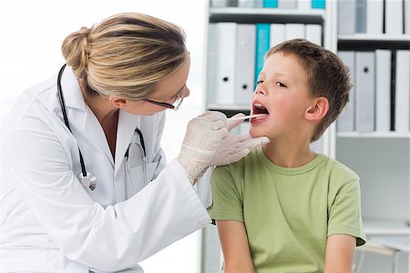 simsearch:400-06734647,k - Female doctor checking mouth of boy in clinic Stock Photo - Budget Royalty-Free & Subscription, Code: 400-07473519