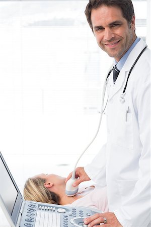 simsearch:400-07474040,k - Portrait of confident male doctor using sonogram on neck of female patient Stock Photo - Budget Royalty-Free & Subscription, Code: 400-07473553