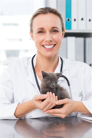 simsearch:400-07473619,k - Portrait of happy female vet holding kitten in clinic Foto de stock - Royalty-Free Super Valor e Assinatura, Número: 400-07473586