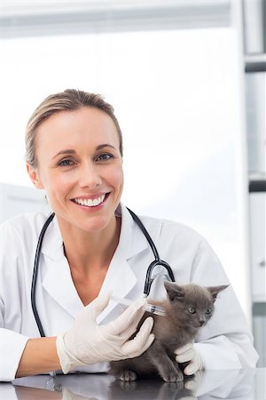 Portrait of smiling female vet injecting a kitten in clinic Stock Photo - Budget Royalty-Free & Subscription, Code: 400-07473590