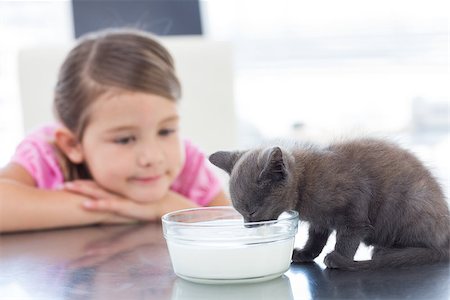 Little girl looking at kitten drinking milk from bowl Stock Photo - Budget Royalty-Free & Subscription, Code: 400-07473637