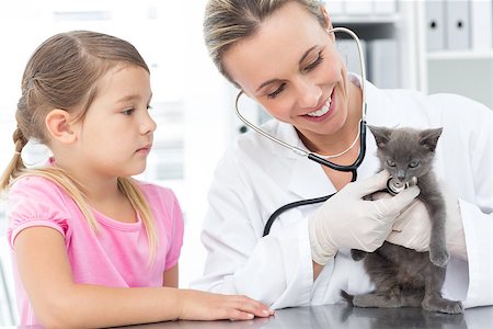 Happy female veterinarian examining kitten with girl in clinic Stock Photo - Budget Royalty-Free & Subscription, Code: 400-07473640