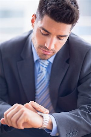 Businessman sitting checking his watch in the office Stock Photo - Budget Royalty-Free & Subscription, Code: 400-07473650