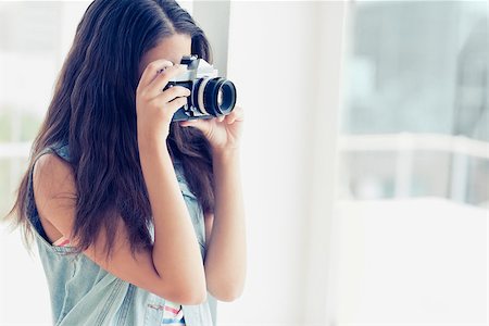 Stylish young photographer taking a photo in a bright room Stock Photo - Budget Royalty-Free & Subscription, Code: 400-07473730