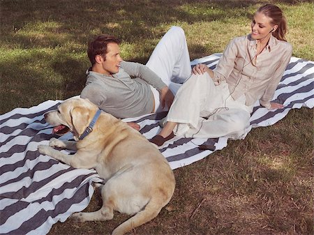 young couple having rest with dog in bloomy garden Foto de stock - Super Valor sin royalties y Suscripción, Código: 400-07485981