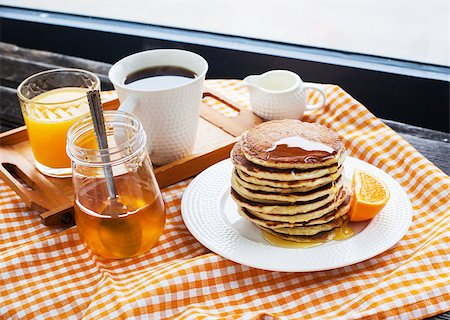 simsearch:400-07917638,k - Breakfast with pancakes, coffee, honey and juice on table at the window Stock Photo - Budget Royalty-Free & Subscription, Code: 400-07480454