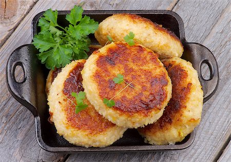 simsearch:400-07478286,k - Delicious Chicken Meat Cutlets in Black Saucepan with Parsley isolated on Rustic Wooden background. Top View Stock Photo - Budget Royalty-Free & Subscription, Code: 400-07480693