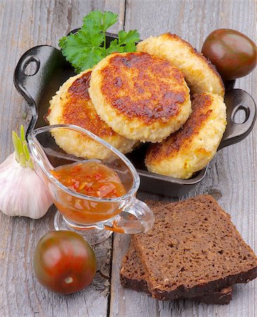 simsearch:400-07481067,k - Arrangement of Delicious Chicken Meat Cutlets in Black Saucepan with Brown Bread, Sauce and Vegetables on Wooden background. Top View Stock Photo - Budget Royalty-Free & Subscription, Code: 400-07481067