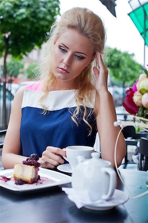 a beautiful young blond girl in summer dress at the table in pavement cafe is having a headache Stock Photo - Budget Royalty-Free & Subscription, Code: 400-07481372
