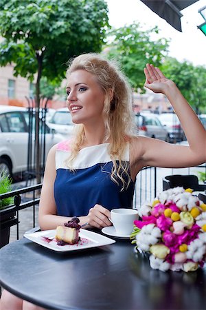 a beautiful young blond girl with a toothy smile in summer dress at the table in pavement cafe is waving someone Stock Photo - Budget Royalty-Free & Subscription, Code: 400-07481373