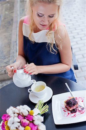 a beautiful young blond girl in summer dress at the table in pavement cafe is pouring green tea from the teapot into a white ceramic cup Stock Photo - Budget Royalty-Free & Subscription, Code: 400-07481388