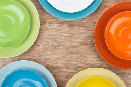 simsearch:400-07331603,k - Colorful plates and saucers over wooden table background. View from above with copy space Foto de stock - Super Valor sin royalties y Suscripción, Código: 400-07481747