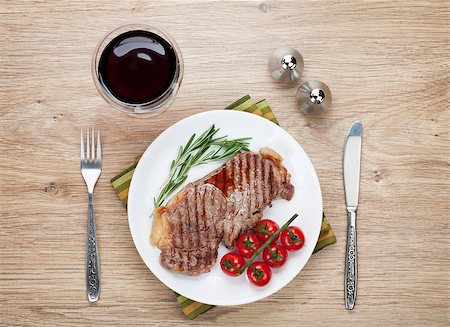 fork and knife on red - Sirloin steak with rosemary and cherry tomatoes on a plate with wine. View from above Foto de stock - Super Valor sin royalties y Suscripción, Código: 400-07481778