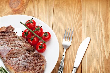 simsearch:400-08495308,k - Sirloin steak with rosemary and cherry tomatoes on a plate. Closeup view from above Stockbilder - Microstock & Abonnement, Bildnummer: 400-07481780