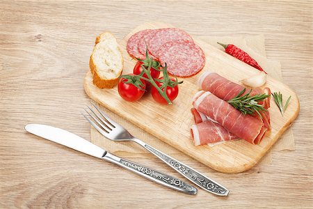 simsearch:400-07481826,k - Prosciutto, salami, bread, vegetables and spices. Over wooden table background Stock Photo - Budget Royalty-Free & Subscription, Code: 400-07481817