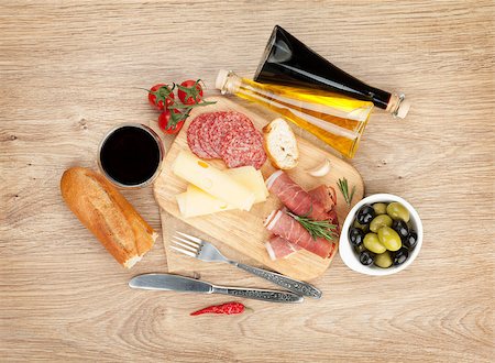 simsearch:400-07481817,k - Red wine with cheese, olives, tomatoes, prosciutto, bread and spices. Over wooden table background. View from above with copy space Stock Photo - Budget Royalty-Free & Subscription, Code: 400-07481818